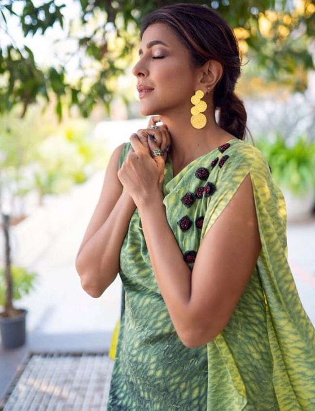 lakshmi manchu in green sleeveless top with golden earrings